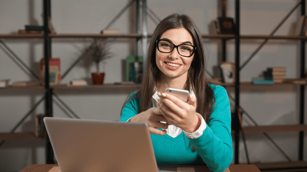 woman website designer laughing, green t-shirt, laptop